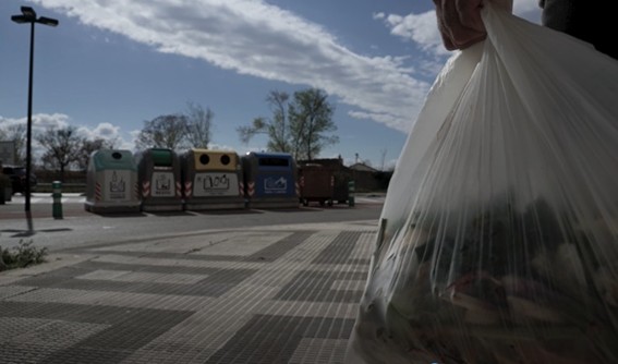 Persona llevando bolsa de basura a los contenedores